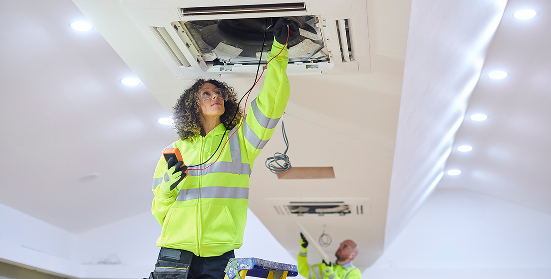 Woman reaching into an AC duct