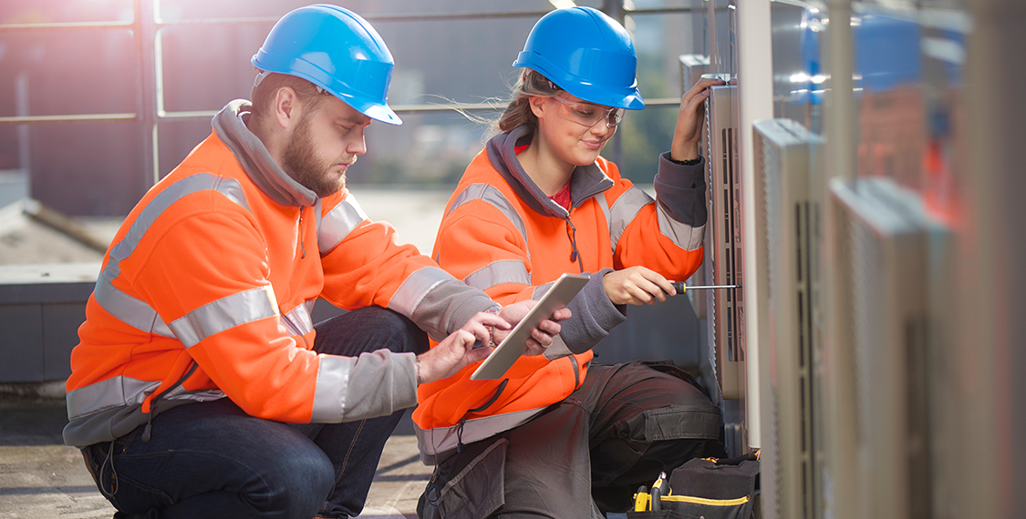 A team of two working on HVAC units
