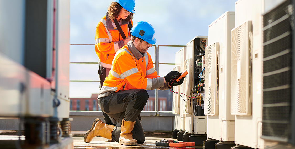 Two AC Technicians wearing safety jackets while working