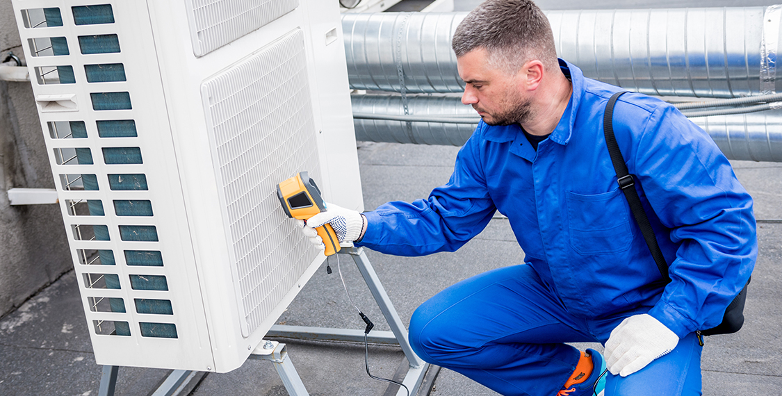 Technician performing maintenance on a HVAC unit