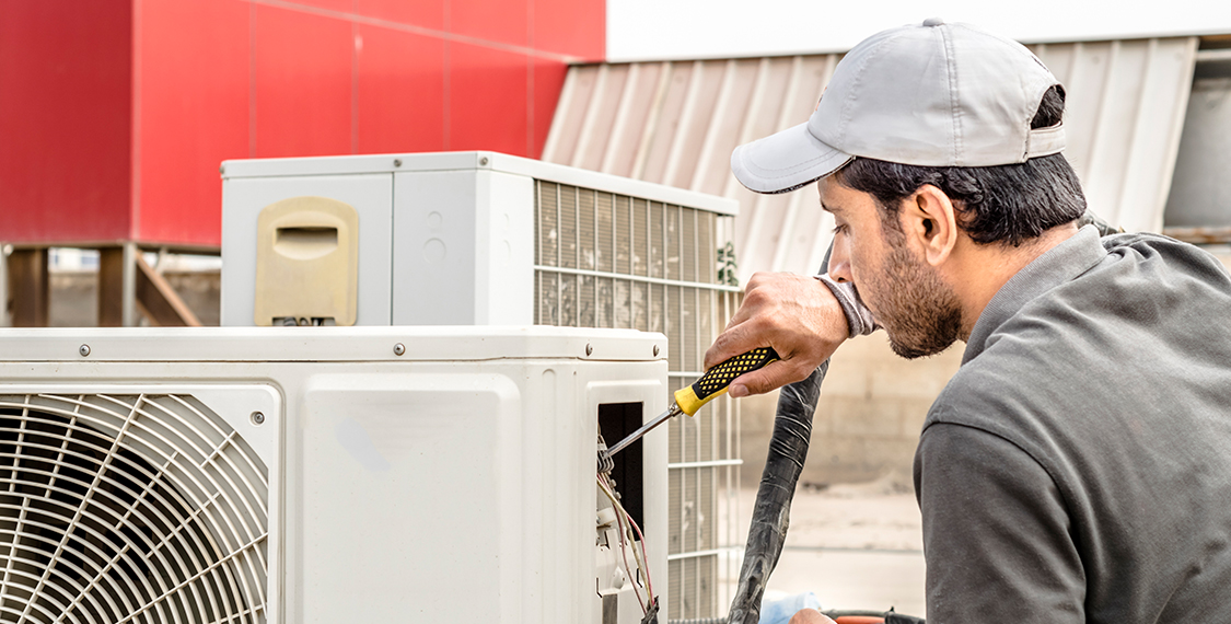 Technician performing a repair on a HVAC unit