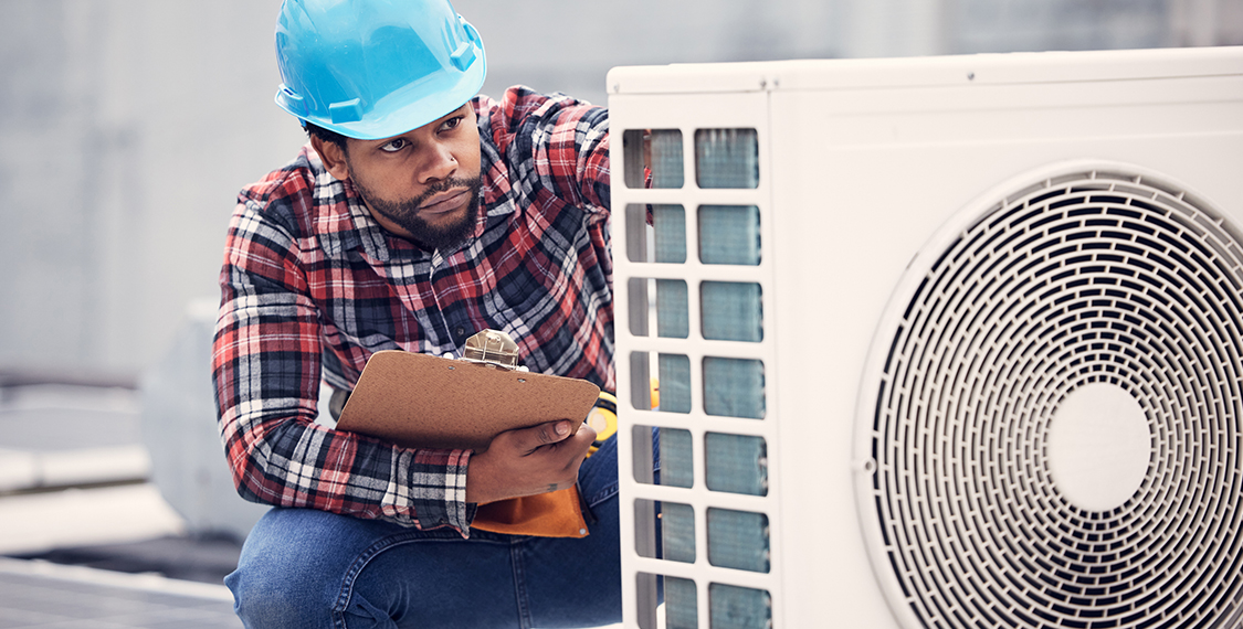 Technician performing maintenance on a HVAC unit