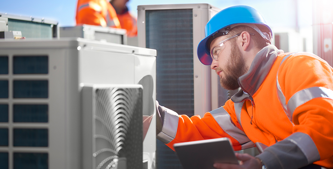 Technician performing maintenance on a HVAC unit