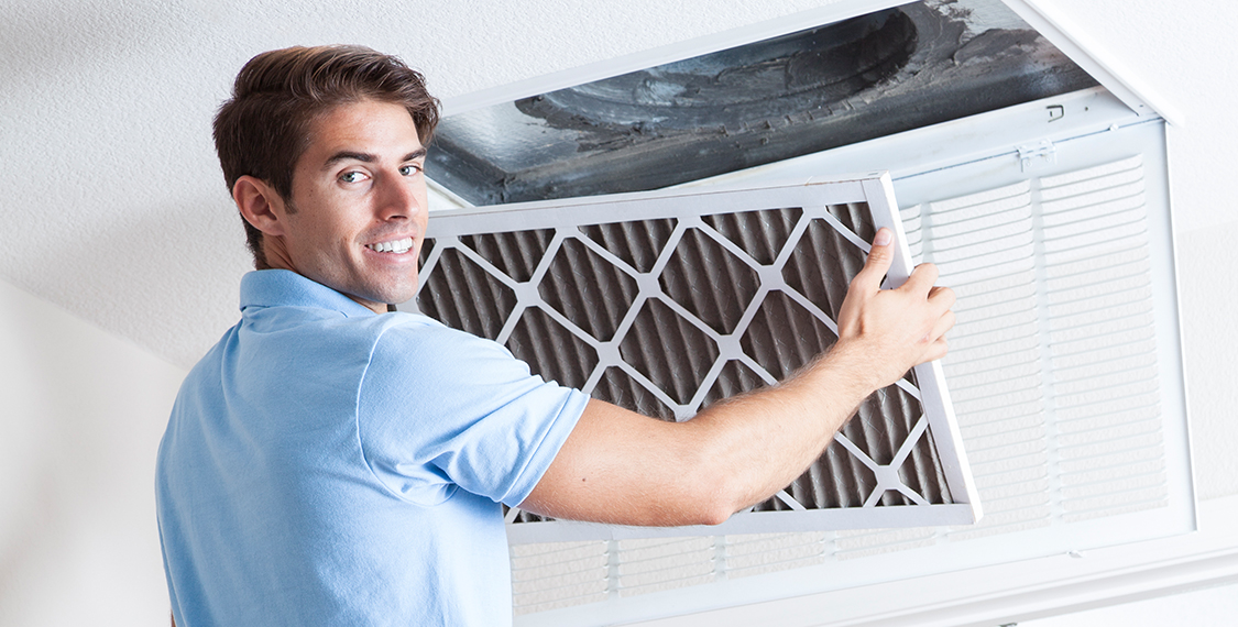 Technicians replacing an air filter