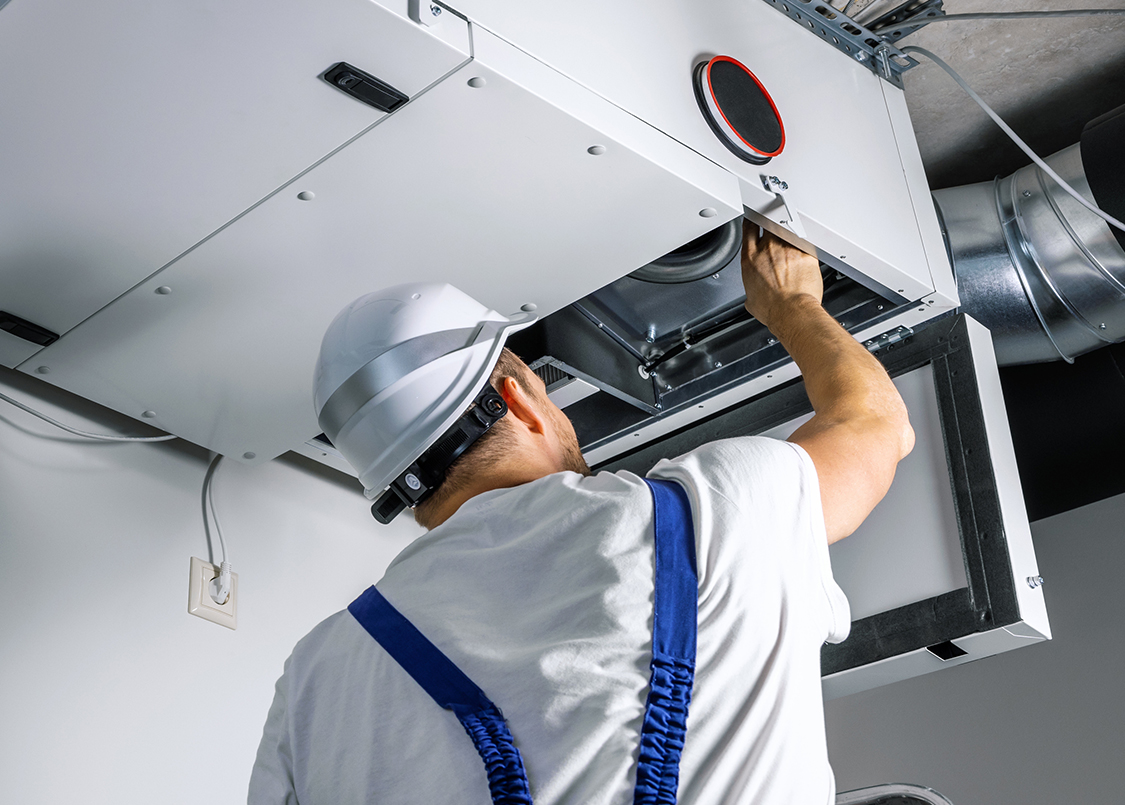 Technician inspecting an air duct